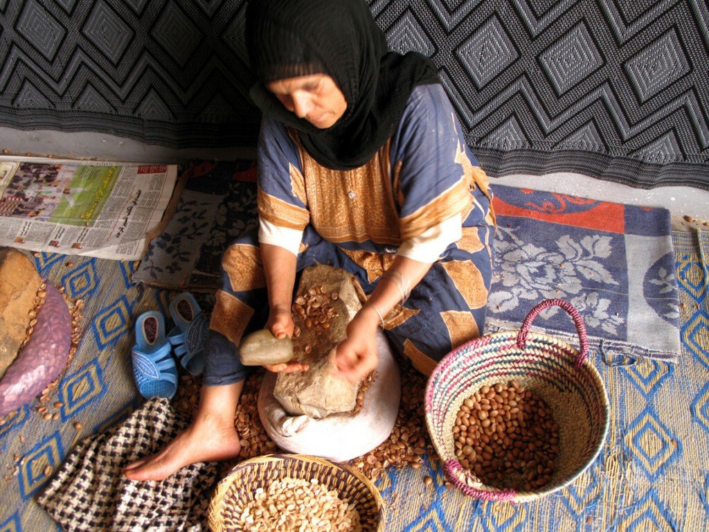 Mujer pelando semillas de argán