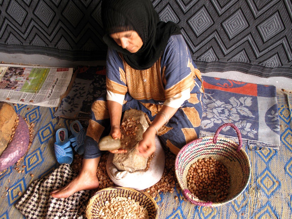 Mujer pelando semillas de argán